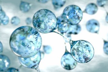 Klarblaue Wassermoleküle schweben und verbinden sich in einer abstrakten und leicht verschwommenen Umgebung, die an Luft oder Wasser erinnert.