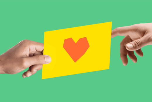 Zwei Hände halten gemeinsam eine gelbe Karte mit einem roten Herzsymbol vor einem grünen Hintergrund.