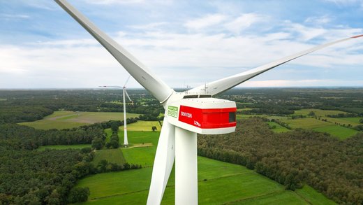 Nahe Drohnenaufnahme einer Windanlage von hinten.